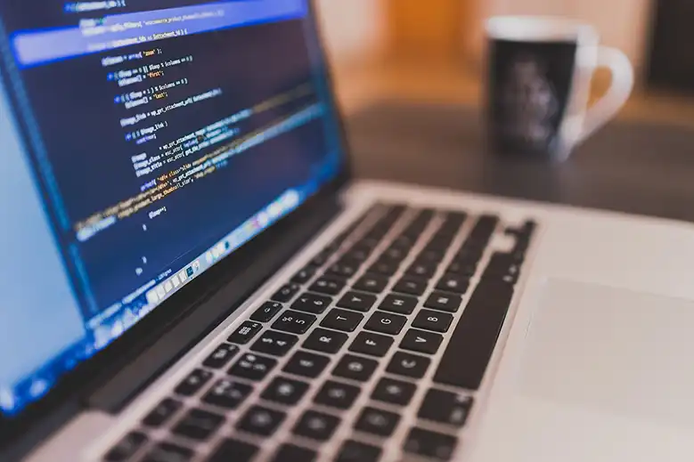 Laptop mostrando código de programación en la pantalla