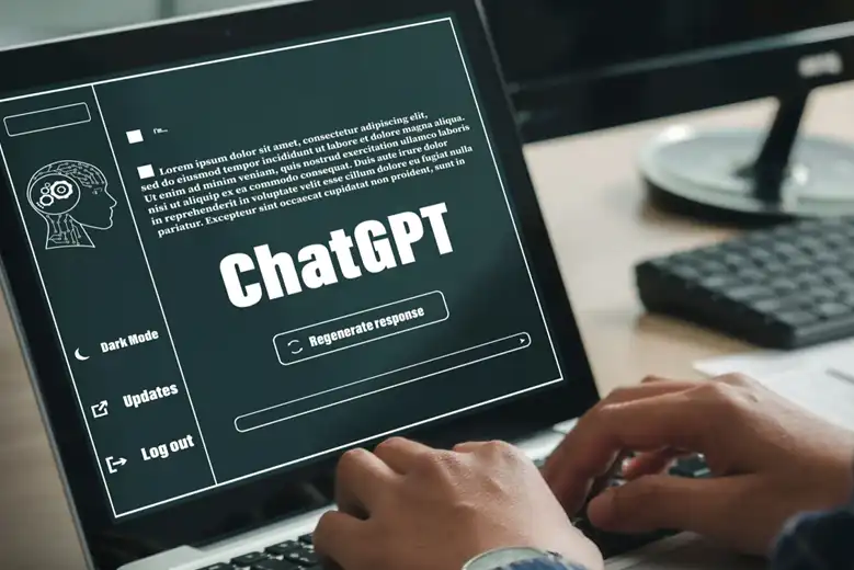 Manos tecleando en laptop que muestra a ChatGPT en la pantalla